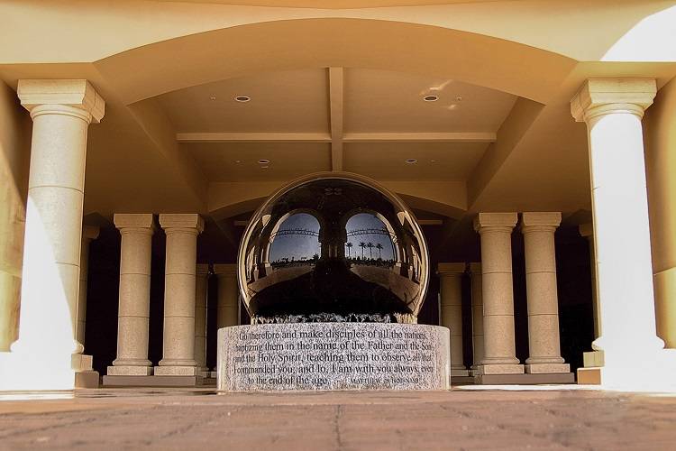 A large art installation on the CBU campus with a black sphere resting on a stone base